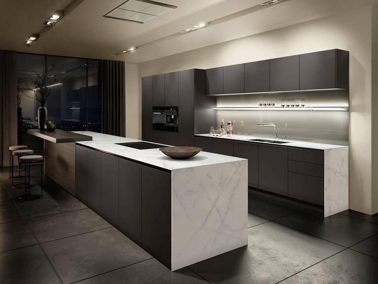 Handleless kitchen from the Pure style collection with SieMatic StoneDesign countertops and side panels in light-colored marble