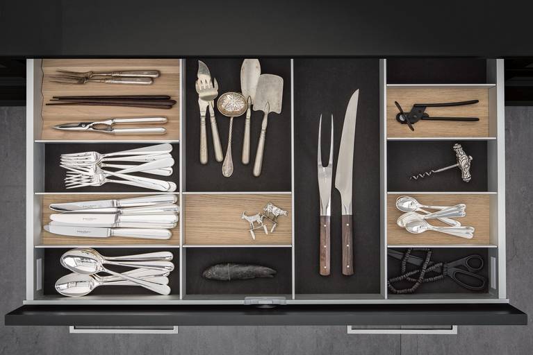Cutlery inserts in light oak on dark grey flocked mats in SieMatic kitchen drawer