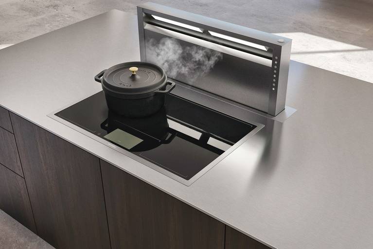 Integrated downdraft extractor in SieMatic Pure SE kitchen island with door and drawer fronts in smoked oak and countertop in stainless steel