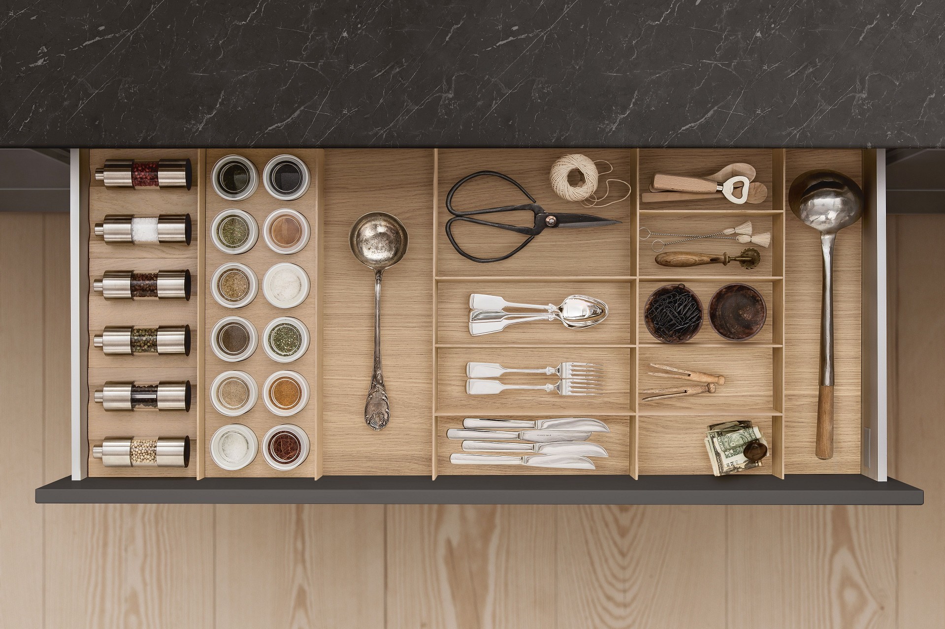 Cutlery, spice mills, and porcelain jars in a drawer in a SieMatic kitchen