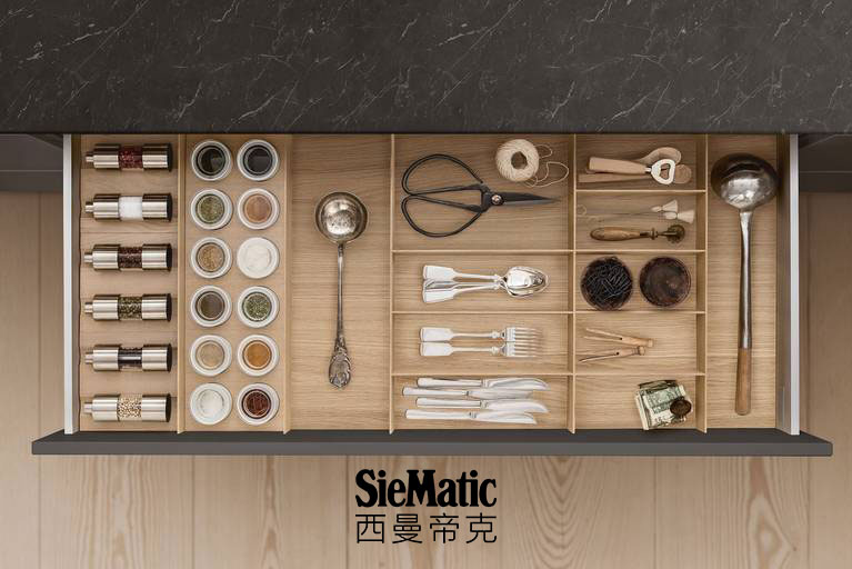 Cutlery, spice mills, and porcelain jars in a drawer in a SieMatic kitchen