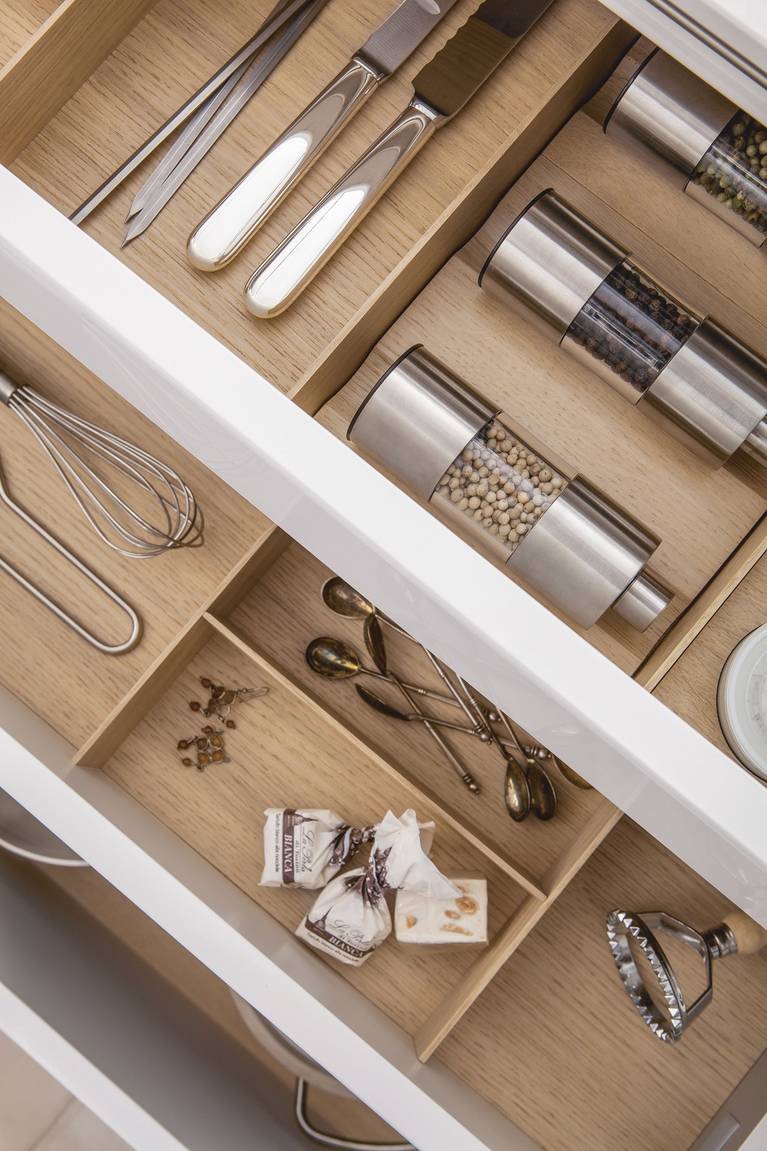 Spice mills and porcelain jars inside a SieMatic drawer with wooden accessories