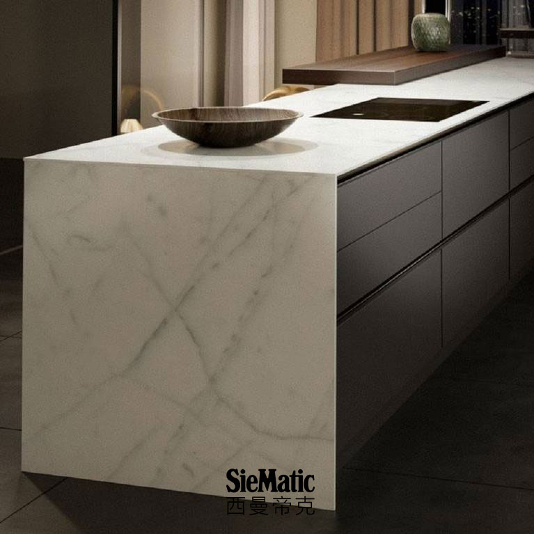 Minimalist kitchen design with handleless island, with SieMatic StoneDesign countertop and side panels in bright marble