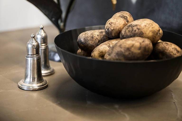 Salt and pepper shakers and a bowl of potatoes on a SieMatic countertop